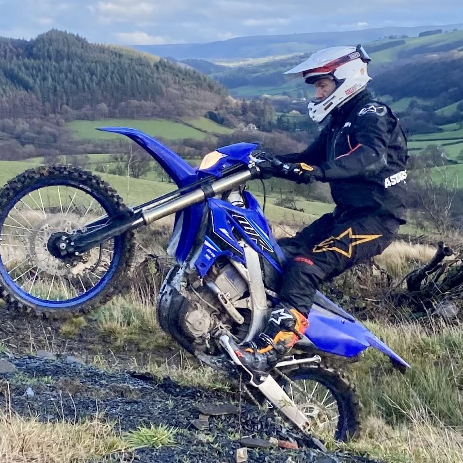 Yamaha WR250F lifting the front wheel with beautiful Mid Wales scenary in the background at the Yamaha Off Road Experience
